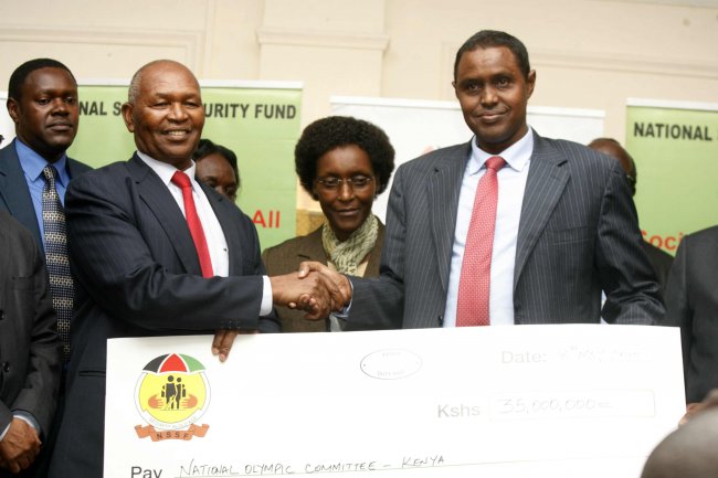 Dr. Kipchoge Keino receives the dummy cheque from NSSF Chairman Adan Mohamed.(Photo by Shutterspeed)