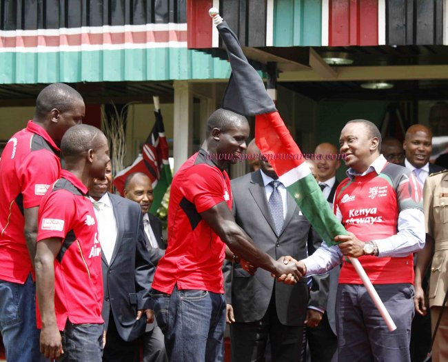 President Uhuru Kenyatta presents the flag to Kenya 7s captain Andrew Amonde at State House.(Photo by Shutterspeed)