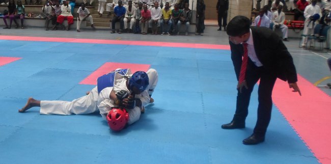 Kenya’s Boniface Njagi (in blue) pins down Mike Macharia during their sparring bout at the 2016 Mombasa Open Tong-IL-Moo-Do International  Championship at Aga Khan Academy.